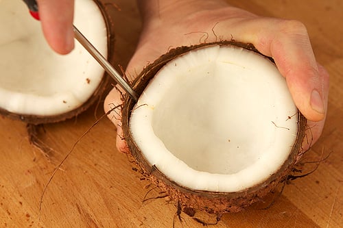 Close up of man hand grated coconut using an electric coconut grater in  Thailand Stock Photo